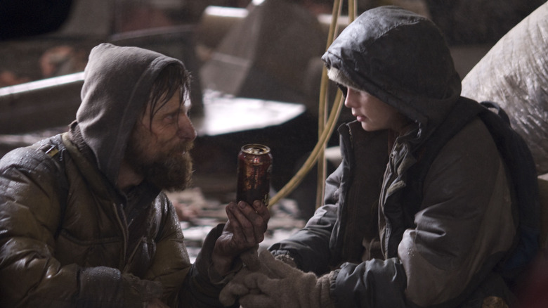 father giving his son a soda can in The Road (2009)