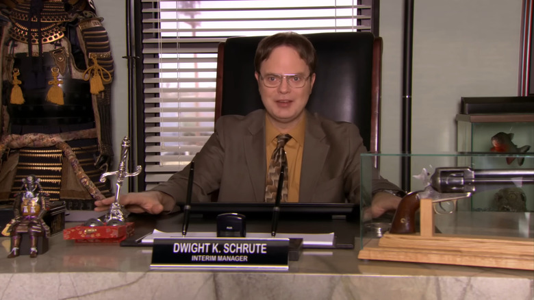 Dwight Schrute sitting behind a marble desk on The Office