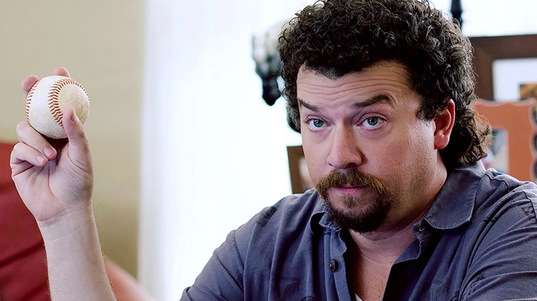 Kenny holding a baseball on Eastbound & Down