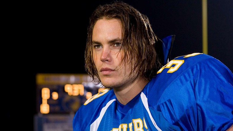 Riggins on the field looking at something on Friday Night Lights