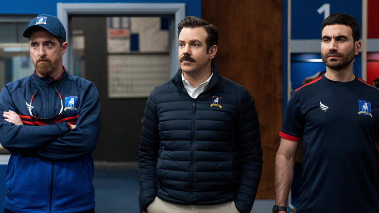 Beard Ted and Roy looking at something on Ted Lasso