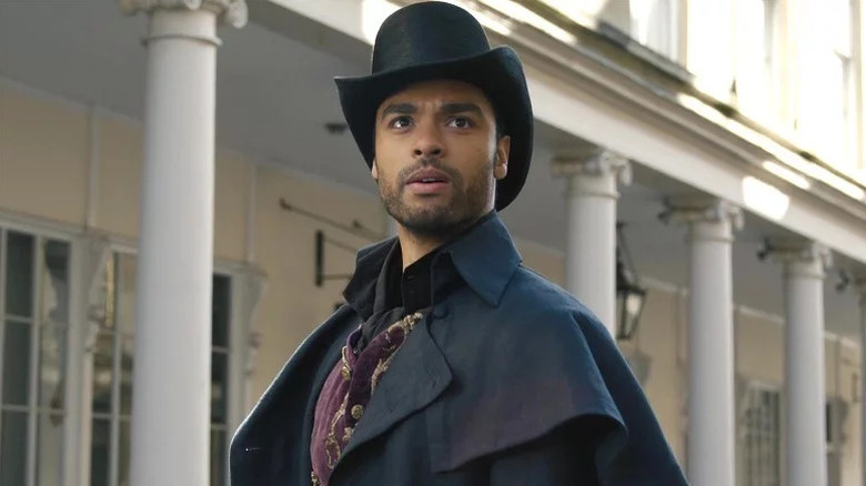 Simon Basset wearing a hat and standing in front of columns on "Bridgerton" (2020-present)