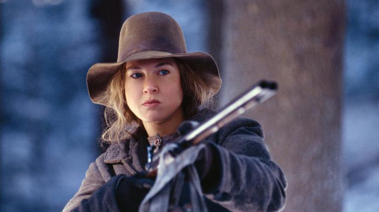 Ruby holding a shotgun and wearing a hat in Cold Mountain