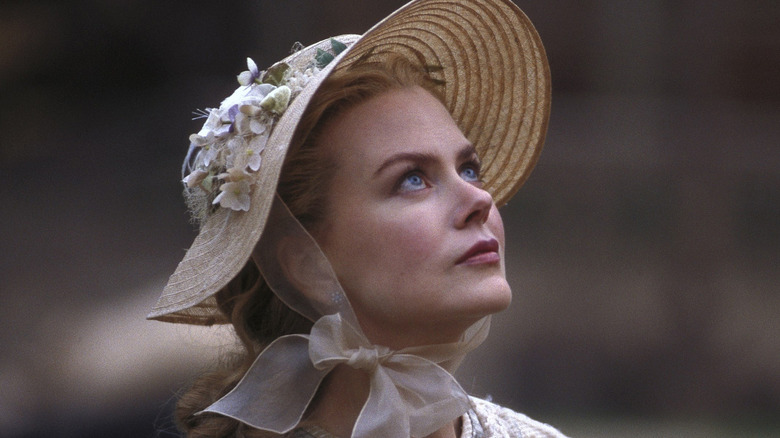 Ada in a decorated hat looking up in Cold Mountain