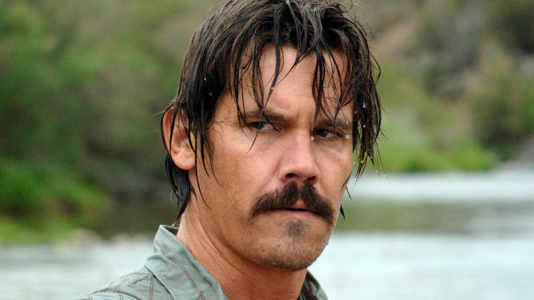 Llewelyn Moss stands in a riverbed in 