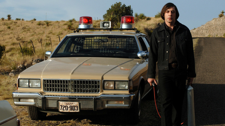 Anton Chigurh stands by a cop car in "No Country for Old Men" (2007)