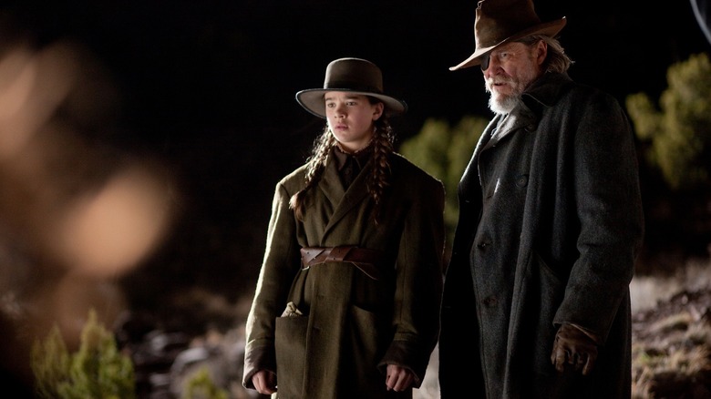 Mattie Ross and Rooster Cogburn assessing a situation in True Grit (2010)
