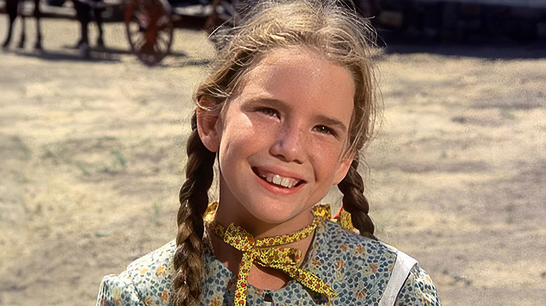 Laura wearing pigtails and smiling on Little House on the Prairie
