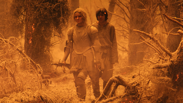 Galadriel and Theo walk through ashy country in "The Rings of Power" (2022-present)