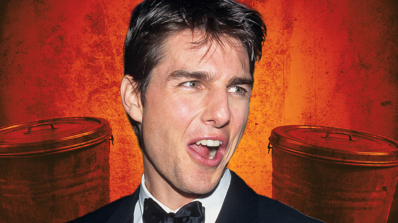 Tom Cruise standing against an orange backdrop and two trash cans (2026)