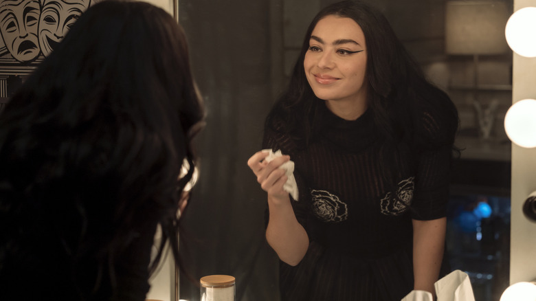 Charli XCX looking at herself in the mirror on Overcompensating