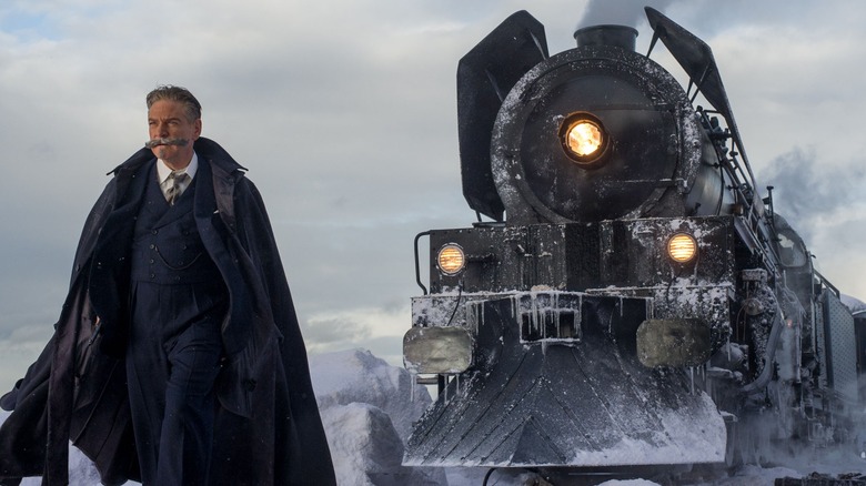 Poirot walks ahead of the train