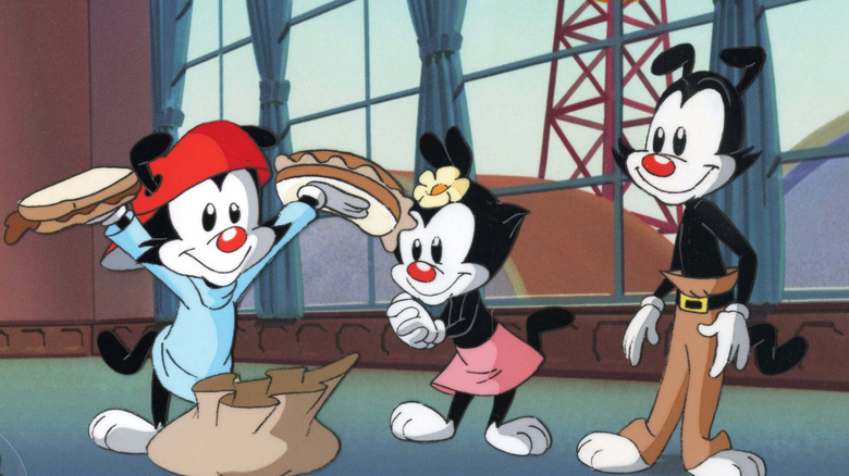 Wakko Warner holds up two sandwiches as Dot and Yakko look on in "Animaniacs"