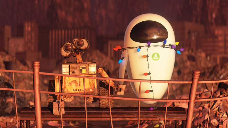 WALL-E and EVE hold hands in the ruins in "WALL-E" (2008)