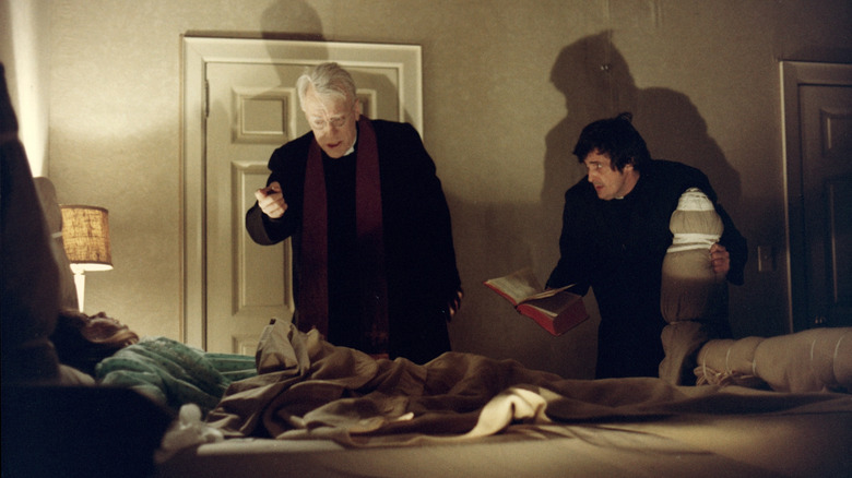 Fathers Karras and Merrin pray over Regan MacNeil in "The Exorcist"