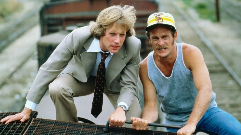 A.J. and Rick Simon crouching on top of a train car on Simon & Simon