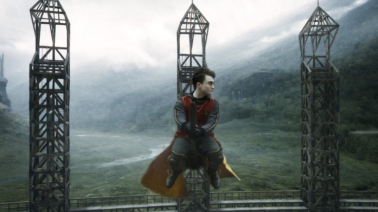Harry sitting on his broom in midair during a Quidditch game at the Hogwarts pitch