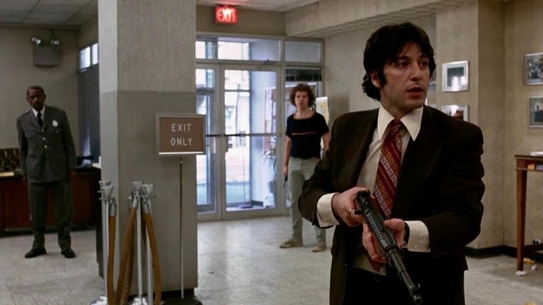 Sonny Wortzik holds a rifle as he stands in the middle of a bank floor in "Dog Day Afternoon"