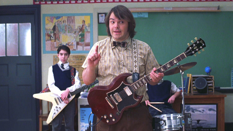 Dewey playing guitar while teaching in School of Rock