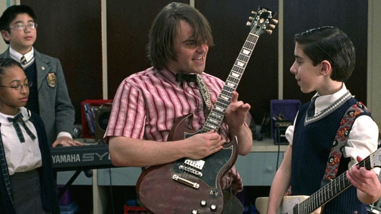 Dewey playing the guitar with students in School of Rock