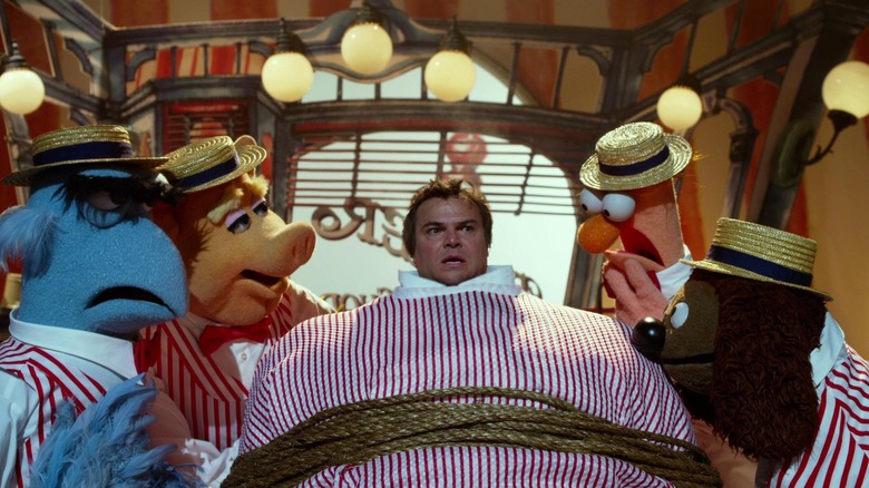 Jack Black in the barber chair surrounded by Muppets in The Muppets
