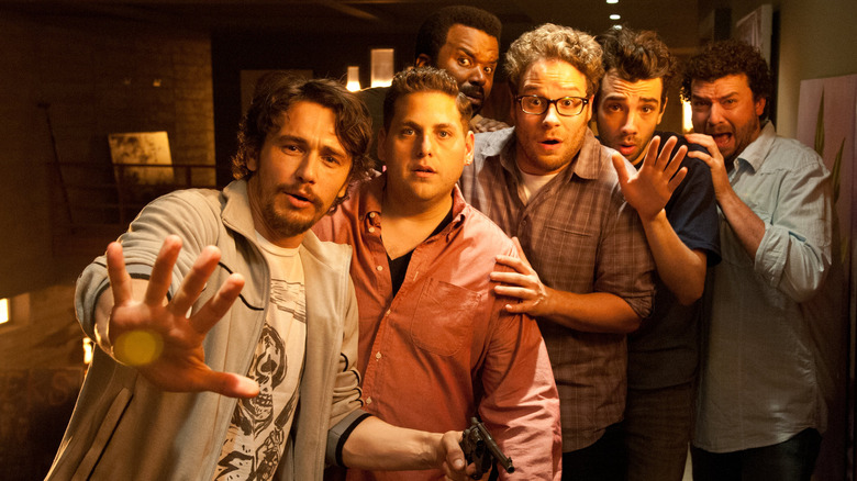 James Franco, Danny McBride, Jay Baruchel, Jonah Hill, Craig Robinson, and Seth Rogen standing fearfully next to each other in This Is the End
