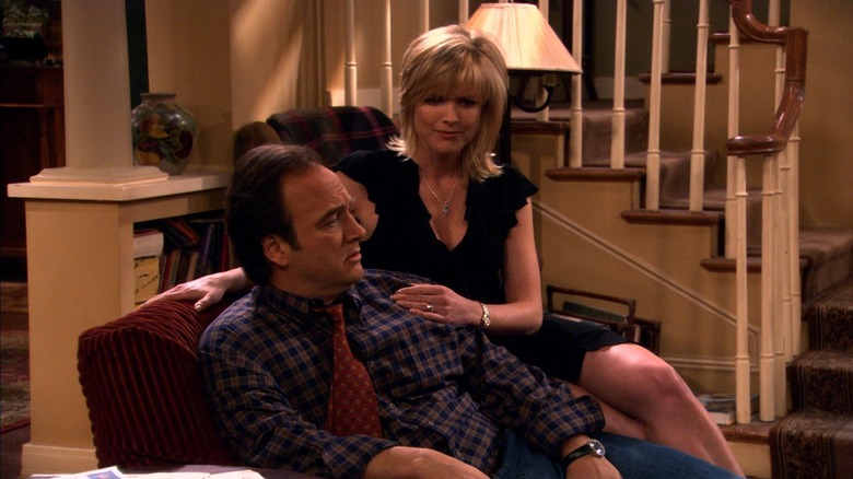 Dana sits on the arm of Jim's chair in "According to Jim"