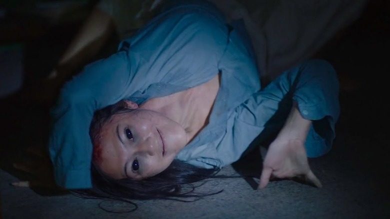 A woman twisted around with dark eyes in Qorin (2022)