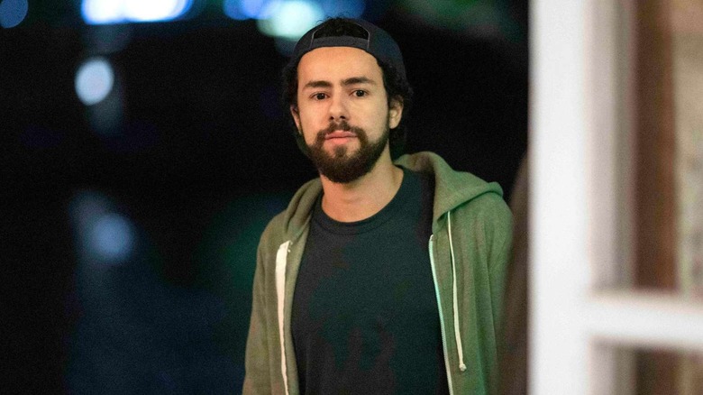 Ramy in a green hoodie and baseball cap on Ramy