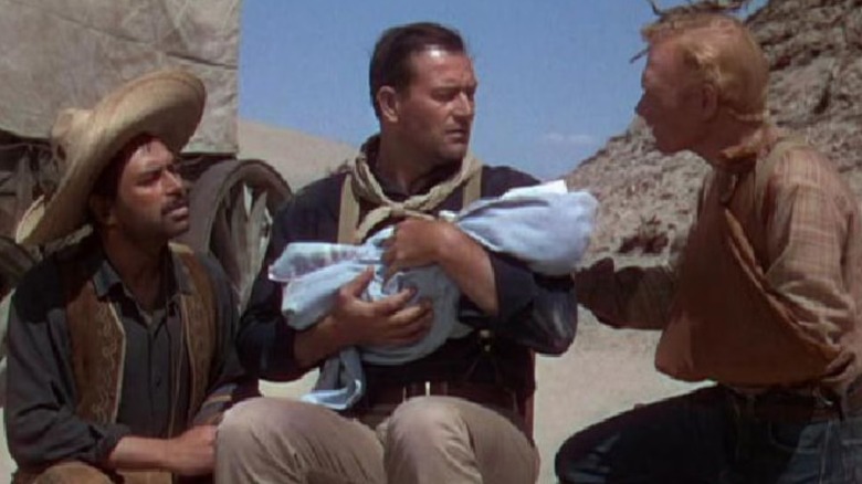 Pedro (Pedro Armendáriz), Robert (John Wayne), and William (Harry Carey Jr.) holding a baby in "3 Godfathers."