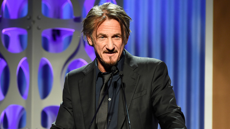 Sean Penn on stage in front of a microphone