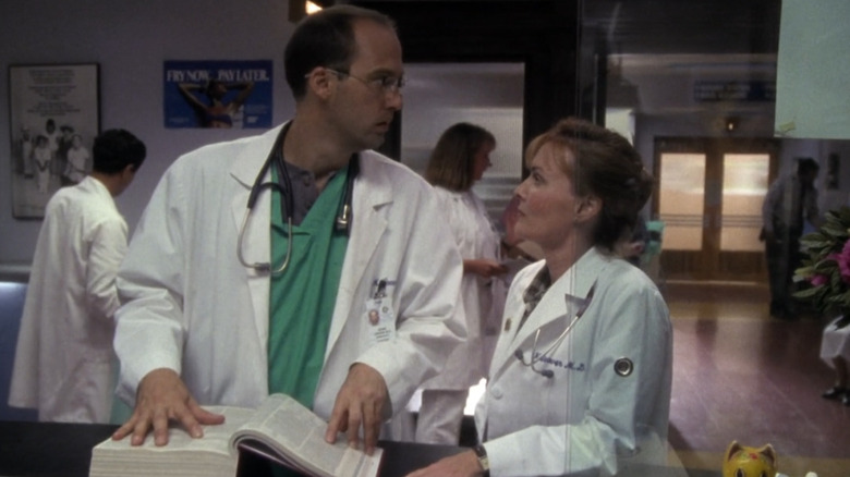 Weaver looks at Green as he thumbs through a book in ER (1994)