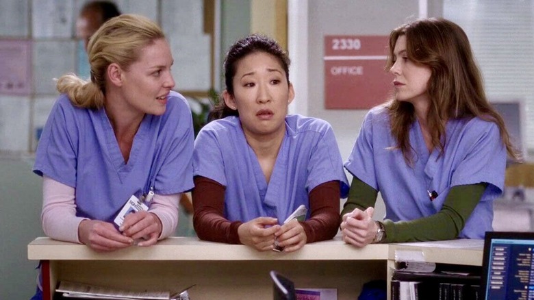 Izzie Stevens, Cristina Yang, and Meredith Grey lean on a desk in "Grey's Anatomy" (2005-present)