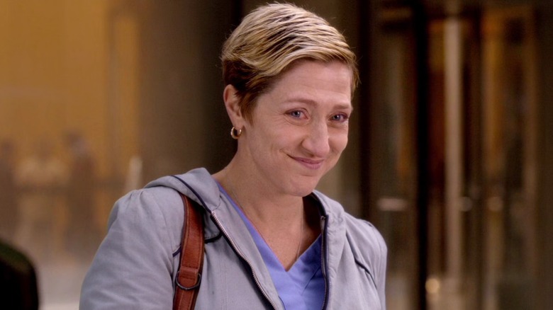 Jackie Peyton standing on the street and smiling on "Nurse Jackie" (2009-2015)