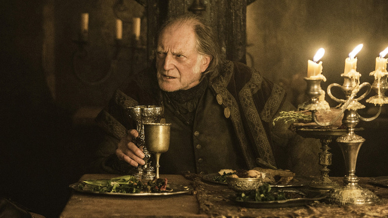 Walder Frey at his table next to a candelabra and goblet on Game of Thrones