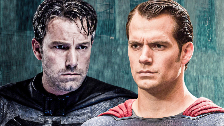 Batman and Superman sporting grimm expressions in front of rainy background