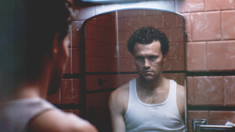 Henry staring at himself in the mirror in "Henry: Portrait of a Serial Killer"