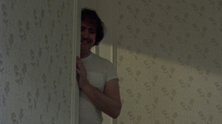 Frank crying behind a door frame in "Maniac"