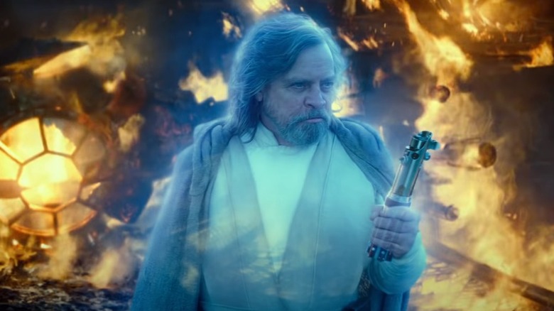 The Force Spirit of Luke Skywalker holding a lightsaber amidst starship wreckage in "The Rise of Skywalker"