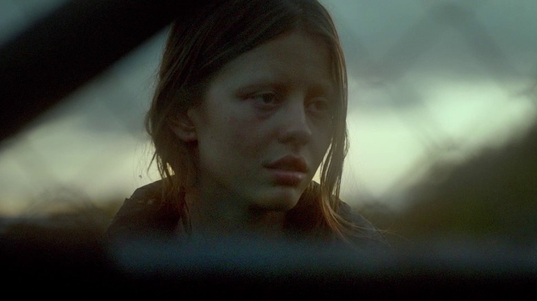 Milja behind a fence in The Survivalist