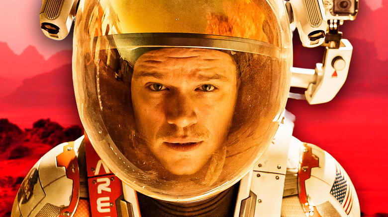 Mark Watney looking confused in a space suit against a red backdrop in The Martian