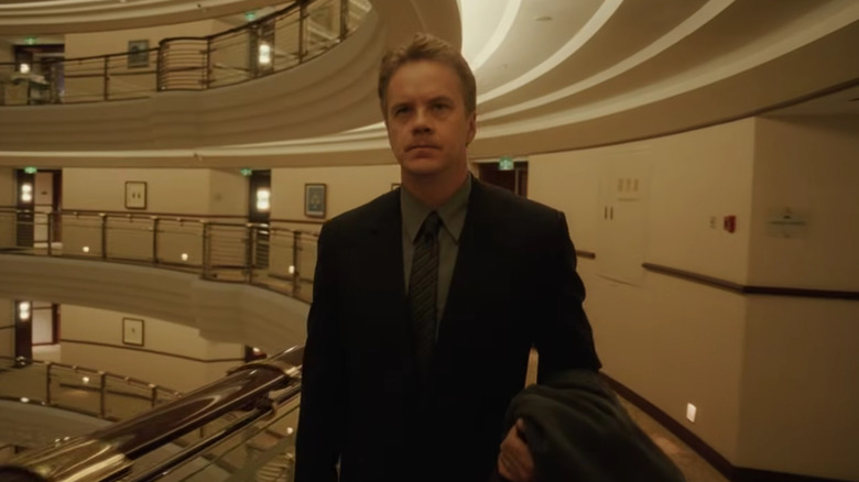 William Geld walking in a vast office building in "Code 46" (2003)