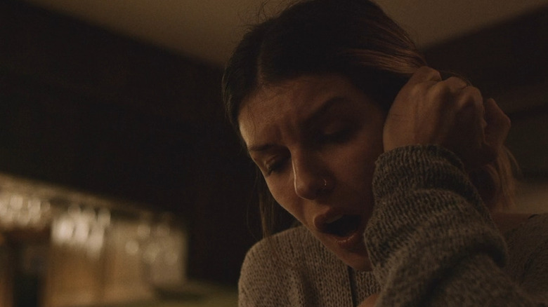 Ashley clutching her ear in "The Rake"