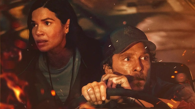 Kevin (Matthew McConaughey) and Mary (America Ferrera) in a bus surrounded by flames in The Lost Bus