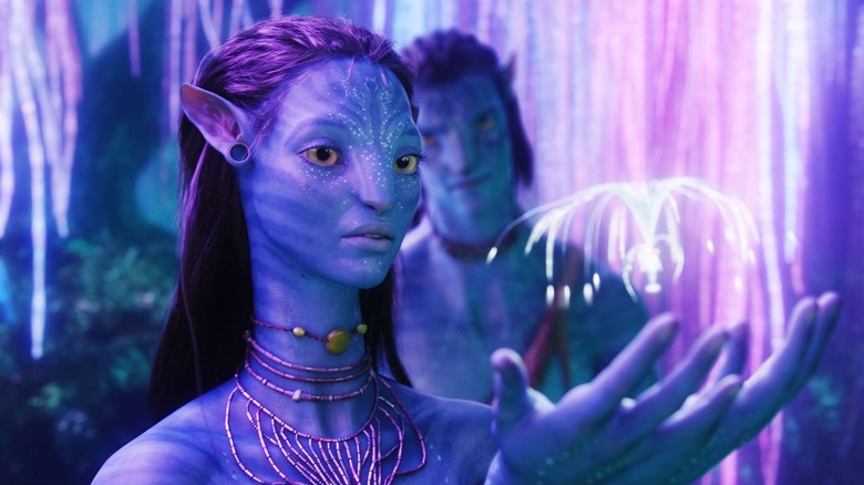 Neytiri tending to an alien critter while talking to Jake Sully in Avatar (2009)