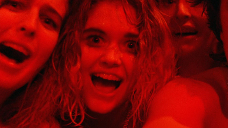 Three girls laughing in red lighting in Society (1989)
