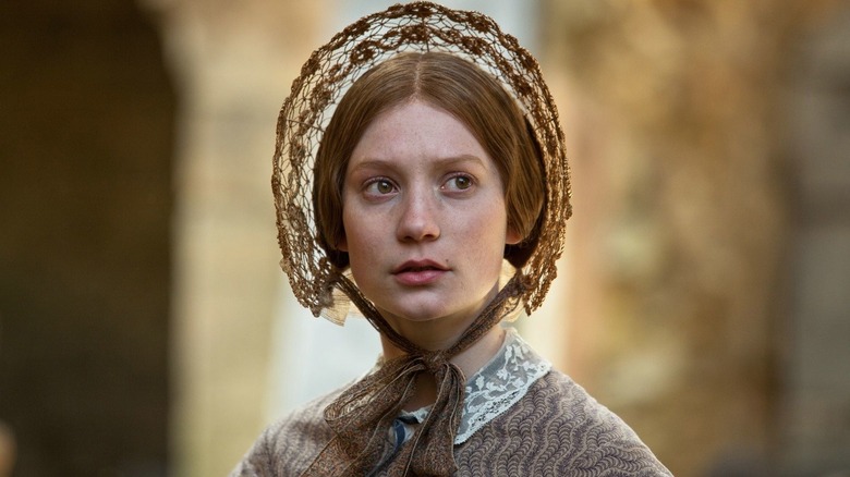 Jane looking to the side wearing a bonnet in Jane Eyre