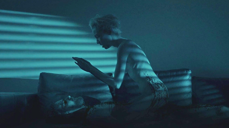 Sarah crouches over a body in Come True (2021)