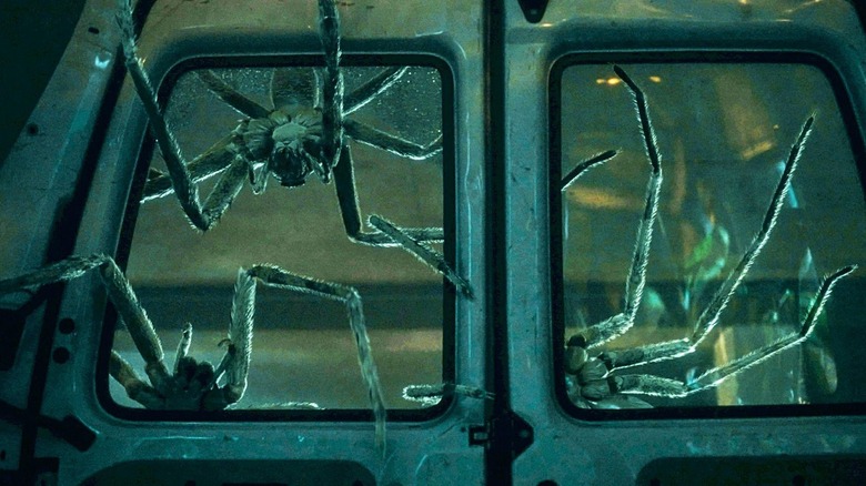 Gigantic spiders trying to get inside a van in Infested (2023)