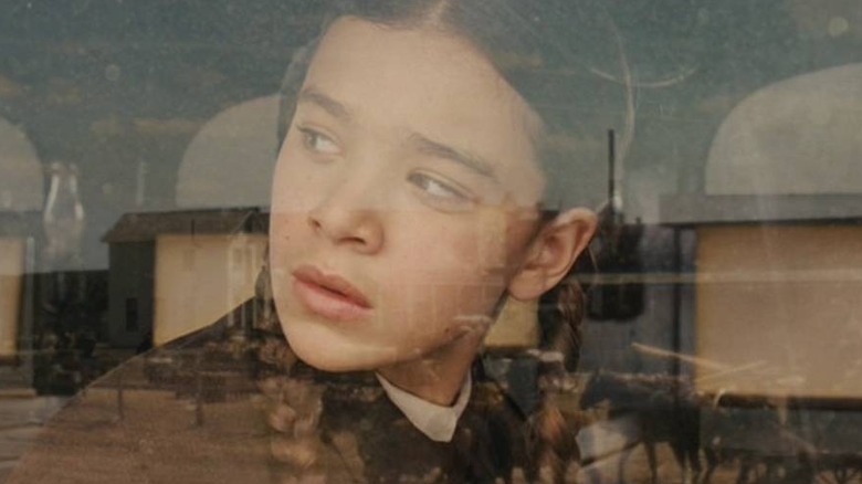 Mattie Ross looking out of a window in True Grit